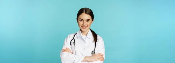 Doctora sonriendo con bata blanca y estetoscopio